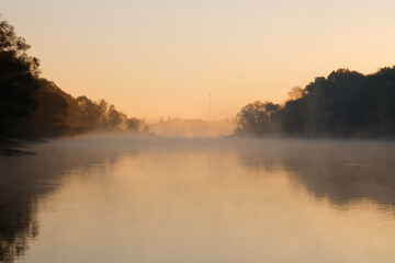 Fototapeta na wymiar Men fishing in river with fly rod during summer morning. Beautiful fog.