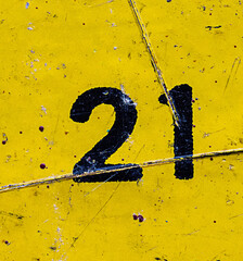 The number 21 is black on a yellow background. Grunge style, scratches and scuffs