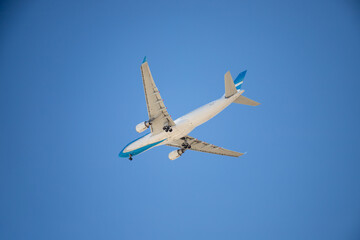 Commercial airplane flying with blue sky in the background