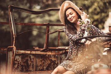 Young Woman Sitting On Abandoned Vehicle At Field