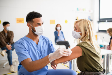 Old woman with face mask getting vaccinated, coronavirus, covid-19 and vaccination concept.