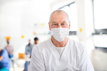Fototapeta na wymiar Portrait of doctor with face mask looking at camera, coronavirus, covid-19 and vaccination concept.