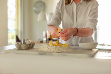 A woman making the dough for a sweet fruit tart at home in the kitchen