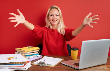 adorable caucasian woman love work in office, she is enjoying work with laptop, smile. isolated red background