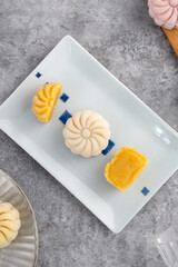 Colorful snow skin moon cake, sweet snowy mooncake, traditional savory dessert for Mid-Autumn Festival on gray cement background, top view