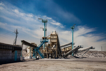 Gold reifinery machine on Metallurgical plant. Rock crushing plant. Modern slag processing machine. Blue sky and clouds.