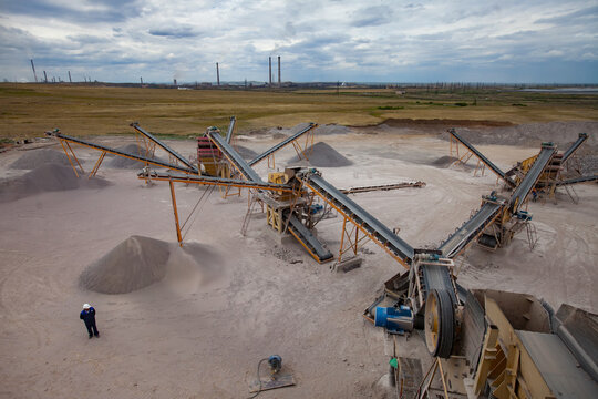 Karaganda/Kazakhstan - June 08 2012: Rock crushing plant. Construction materials production. Gravel separation machine in work. Electric power plant on background.