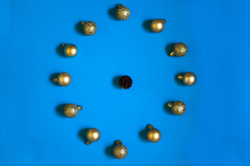 Christmas banner with gold christmas balls and bump clock-shaped on blue background. New year flatlay