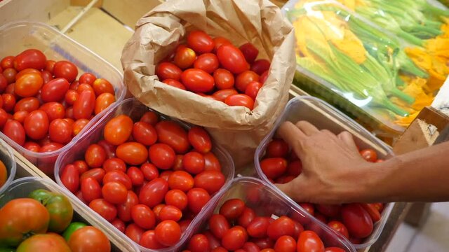 Signora fa la spesa al mercato ortofrutticolo. Italia - pomodori ciliegina - Lady is shopping at the fruit and vegetable market. Italy - cherry tomatoes