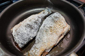 Fish with flour fried in cooking pan with hot oil