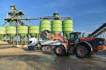 Fototapeta na wymiar Gravel pit: building and wheel loader loading gravel onto a truck