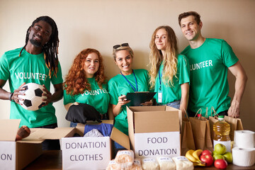 diverse volunteers packing, collecting humanitarian aid in donation box. multi-ethnic group of...