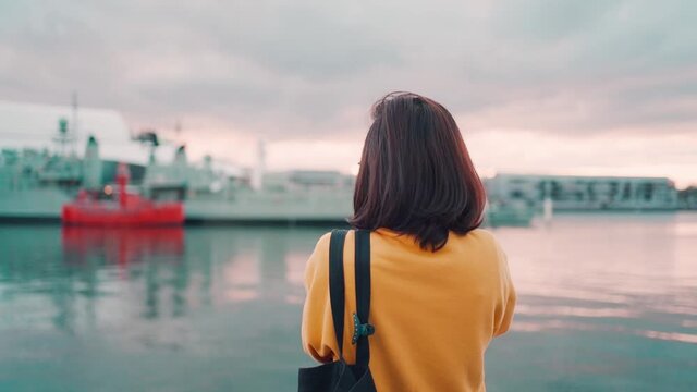 Asian woman tourist take pictures warships at Daring Harbor Sydney , Australia
