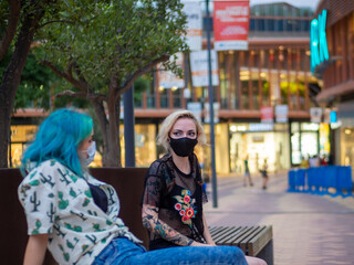 Shot of two women wearing medical masks talking to each other  - new normal
