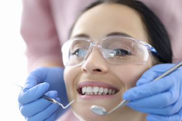 Young woman at dentist's office with instruments in her hands. Dental treatment and prosthetics concept.