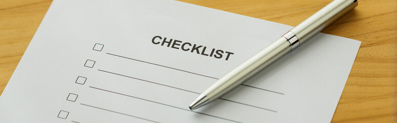 A checklist on the desk. A pen on the table.