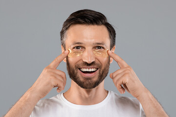 Young man with golden patches under eyes from wrinkles