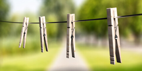 Clothespins on clothes line against nature background. 3d illustration