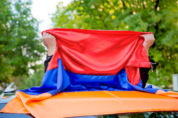 Girl glosing her face and holding armenian flag