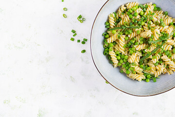 Vegan salad. Fusilli pasta with green peas and onions. Italian food. Top view. Flat lay.