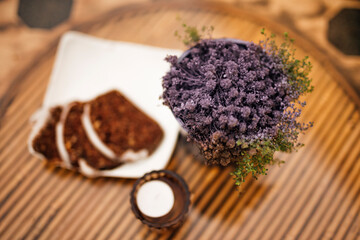 Table decoration with candle lights, flowers and cinnamon bread on wooden table.