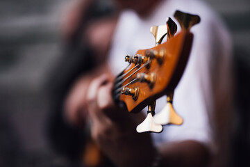 Close up of male hands playing bass guitar.