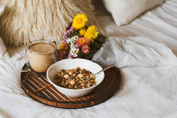 Breakfast in bed with coffee cup and granola on tray. Copy Space. Cozy breakfast