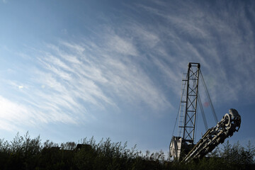 Eimerkettenbagger vor blauem Himmel mit Cirruswolken