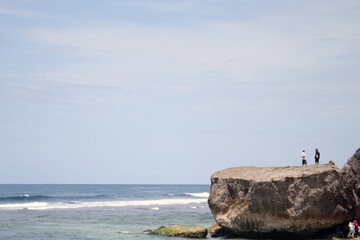 a beach with a small cliff on the edge is often used by people to take pictures