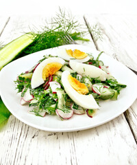 Salad with radish and egg in plate on wooden board