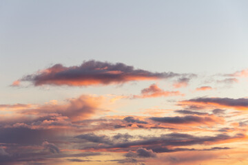 Evening sky with rain clouds in orange-pink sunset light