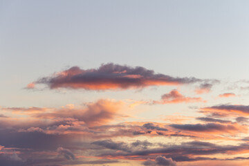 Evening sky with rain clouds in orange-pink sunset light