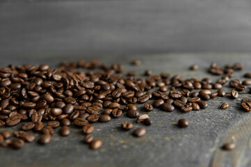 Roasted arabica coffee beans scattered on a wooden table. Fresh coffee beans.