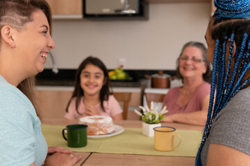 Joyful pretty lesbian couple with big smile spending good time together with family. in kitchen home, indoors. Lgbtq family, bonding, love, generation concept..