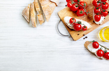 sandwiches with cherry tomatoes salad oil seasoning on a wooden board on a white wooden table top view