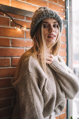 Young woman with long blond hair in sweater and cap