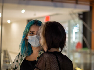 Shot of two women wearing medical masks talking to each other  - new normal