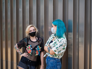 Shot of two women wearing medical masks talking to each other  - new normal