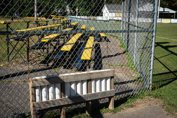 Empty Baseball Bat holder and empty bleacher seats at park in Windsor in Upstate NY