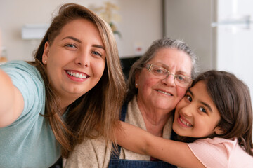 Portrait of brazilian grandmother, mother and granddaughter with big smile looking at camera in...