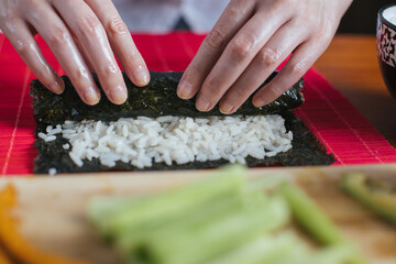 Female chef preparing sushi in the kitchen
