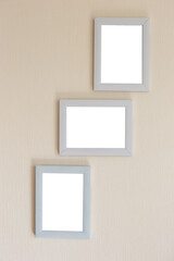Collage of three white frames on a beige wall