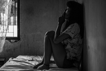 A young Asian woman sitting in a cigarette smoking, unconscious. Drugged, drunkenness
