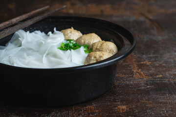 Noodles with meatballs on a wooden table