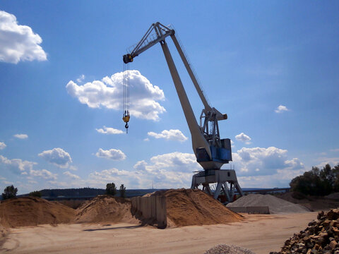 Background with Mining of sand, gravel and stones. Working environment with a crane and material from mining.