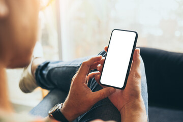 cell phone mockup blank white screen.man hand holding texting using mobile on desk at coffee shop.background empty space for advertise.work people contact marketing business,technology