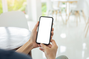 cell phone mockup blank white screen.woman hand holding texting using mobile on desk at coffee shop.background empty space for advertise.work people contact marketing business,technology