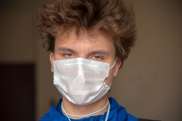 Portrait of a teenage boy in a protective mask on an abstract background.