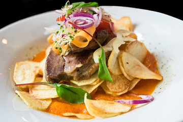 Delicious restaurant dish from Hungarian cuisine - beef steak cooked on medium rare roast, served with homemade potato chips, fresh vegetable salad and red wine sauce