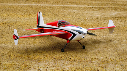  Red and white color RC plane on the ground for take off.                              